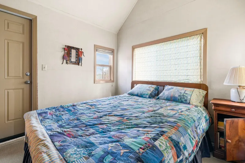 Slide: The Image of Cozy bedroom in a 1976 custom boathouse with colorful quilt and wooden nightstand. - 25