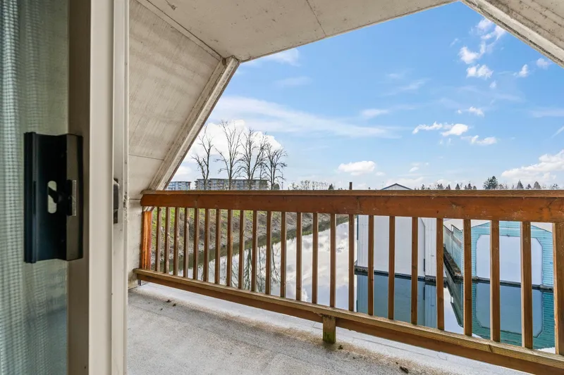 Slide: The Image of 1976 Custom Boathouse balcony view overlooking serene water and clear blue sky. - 29