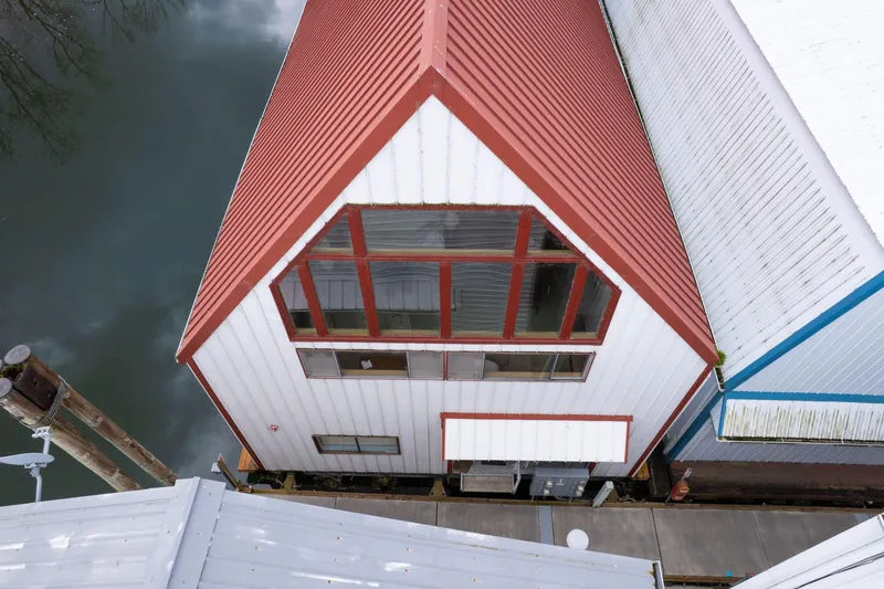 Slide: The Image of Aerial view of a 1976 custom boathouse with red roof and large windows. - 3