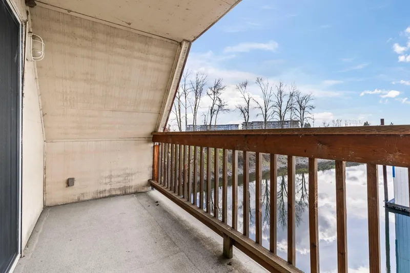 Slide: The Image of Balcony view from a 1976 custom boathouse overlooking a serene waterway and trees. - 30