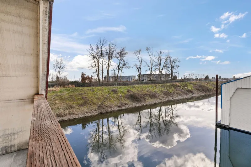 Slide: The Image of View from a 1976 Custom Boathouse overlooking a serene river with tree reflections. - 31