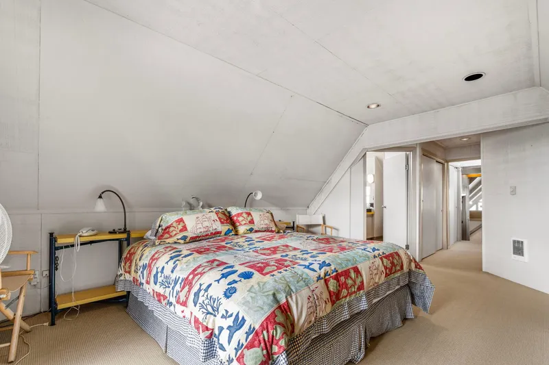 Slide: The Image of Cozy bedroom in a 1976 custom boathouse with colorful quilt and sloped ceiling. - 32