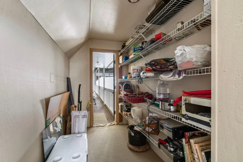 Slide: The Image of Storage room in a 1976 custom boathouse with shelves and various household items. - 35