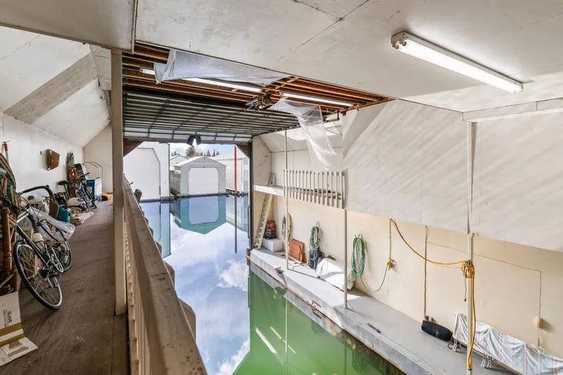 Slide: The Image of Interior of a 1976 custom boathouse with bicycles and water reflection. - 36
