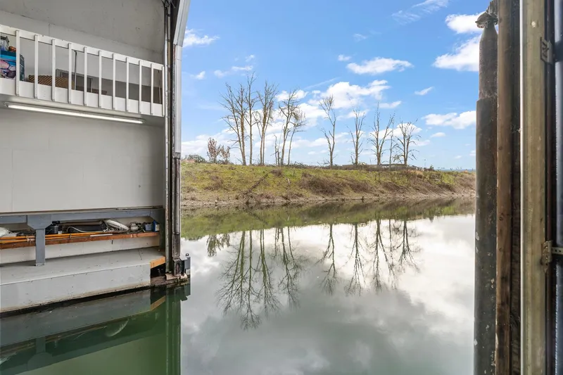 Slide: The Image of Interior view of a 1976 custom boathouse with serene river reflection. - 39