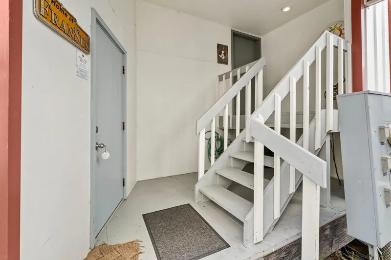Slide: The Image of Entrance of a 1976 custom boathouse with white stairs and a gray door. - 4