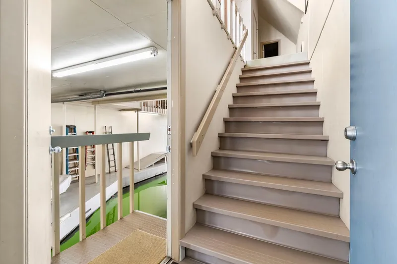 Slide: The Image of Staircase in a 1976 custom boathouse with indoor waterway and storage area. - 5