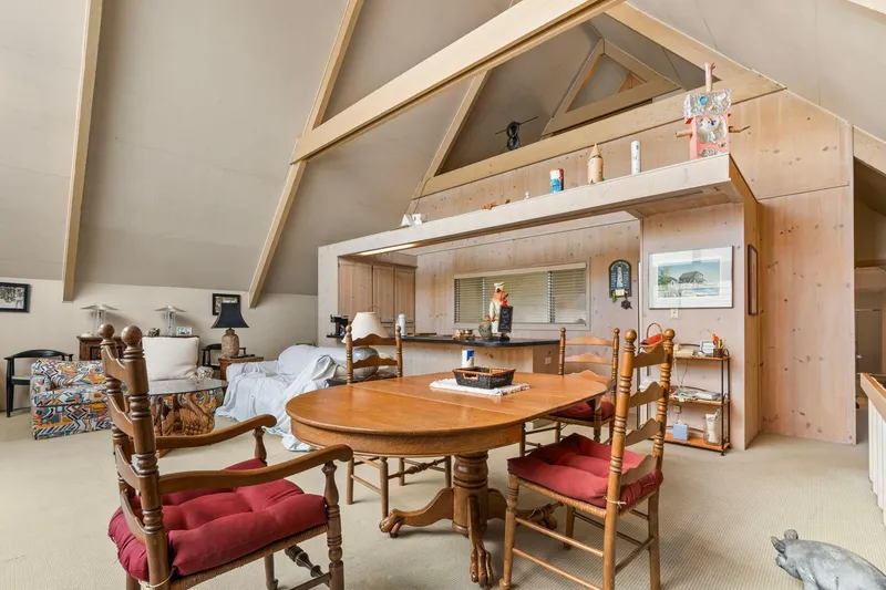 Slide: The Image of Spacious 1976 custom boathouse interior with wooden beams, dining area, and cozy seating. - 9