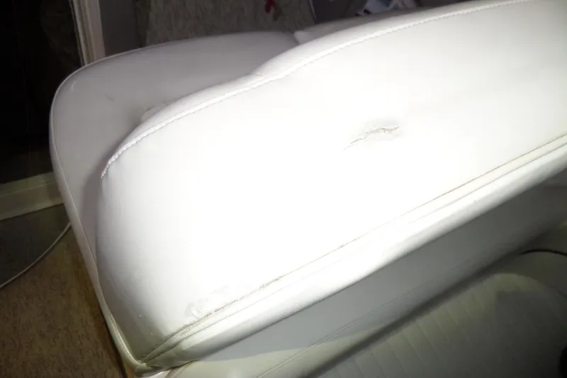 Slide: The Image of White leather seat with a tear on a 2000 Bayliner 3055 Ciera boat. - 2