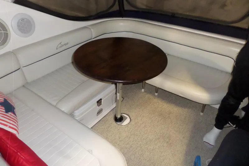 Slide: The Image of Interior of 2000 Bayliner 3055 Ciera with white seating and wooden table. - 26