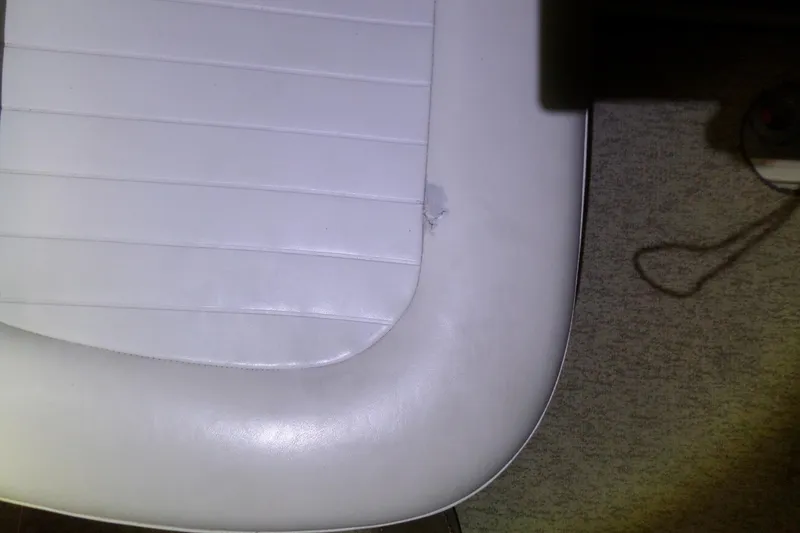 Slide: The Image of White vinyl seat with a small tear on a 2000 Bayliner 3055 Ciera boat. - 3