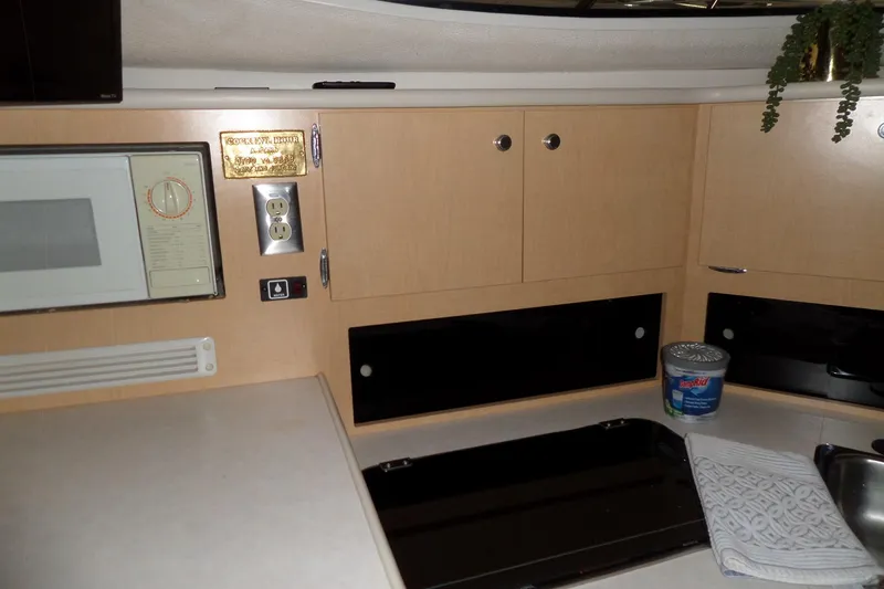 Slide: The Image of 2000 Bayliner 3055 Ciera kitchen area with microwave, cabinets, and countertop. - 37