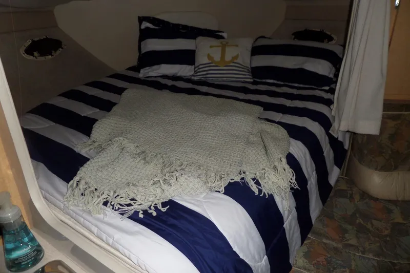 Slide: The Image of Cozy cabin interior of 2000 Bayliner 3055 Ciera with striped bedding and nautical decor. - 42