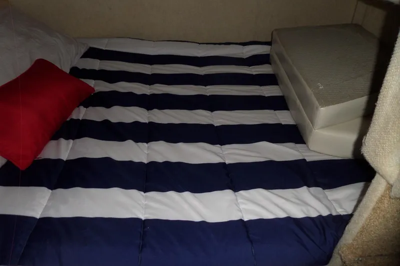 Slide: The Image of Interior of 2000 Bayliner 3055 Ciera with striped bedding and red pillow. - 49
