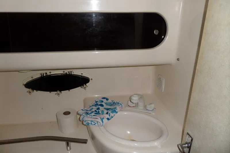 Slide: The Image of 2000 Bayliner 3055 Ciera bathroom with sink, towel, and porthole window. - 51