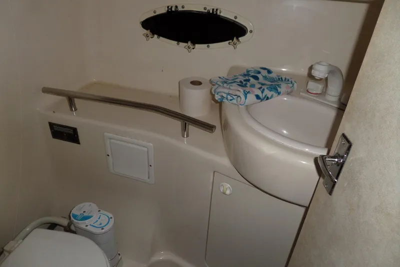 Slide: The Image of Compact bathroom in a 2000 Bayliner 3055 Ciera boat, featuring sink and toilet. - 52