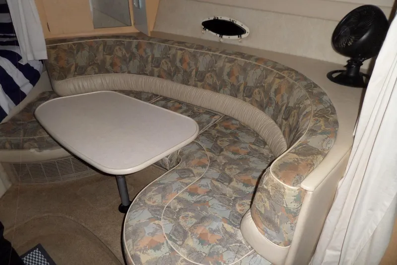 Slide: The Image of Interior of a 2000 Bayliner 3055 Ciera with a curved seating area and table. - 53