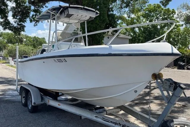 The Image of 1999 Mako 221 Center Console boat on trailer, parked outdoors. - 0