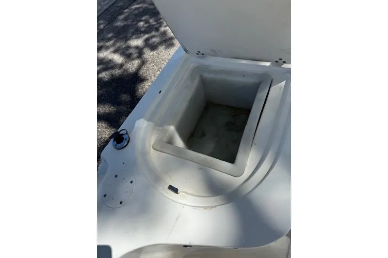 Slide: The Image of Open storage compartment on a 1999 Mako 221 Center Console boat. - 11