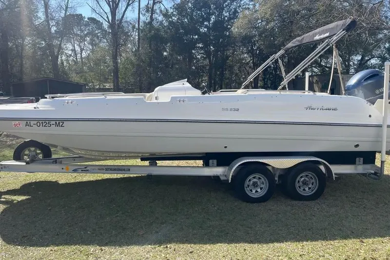 Slide: The Image of 2017 Hurricane SunDeck Sport 232 OB boat on trailer, parked outdoors. - 1