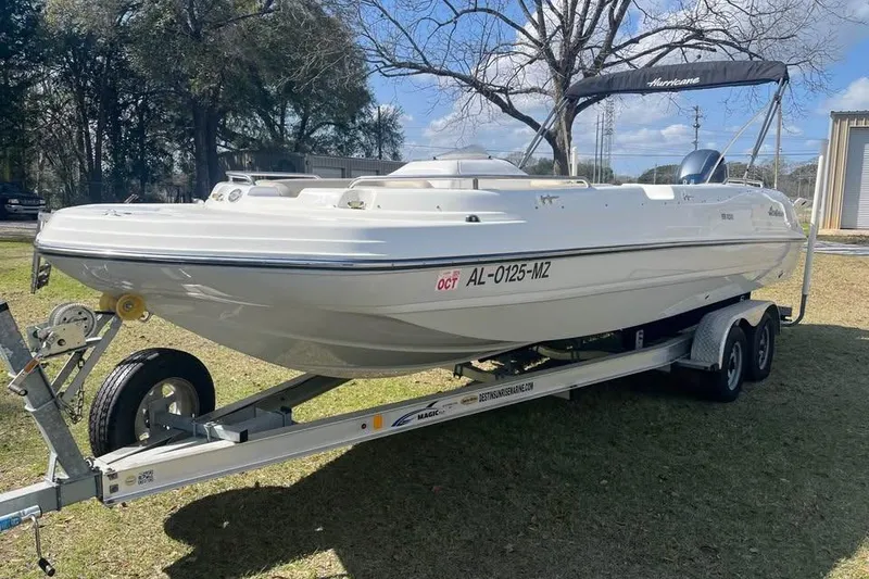 Slide: The Image of 2017 Hurricane SunDeck Sport 232 OB boat on trailer, parked outdoors. - 2