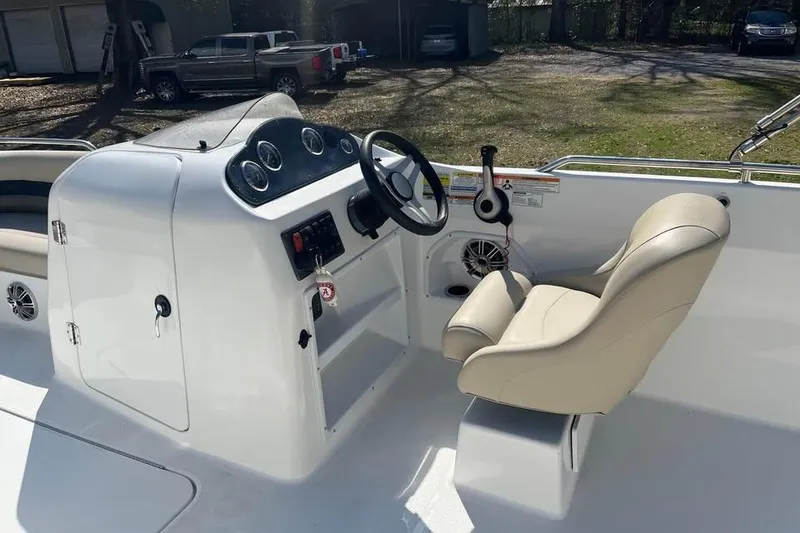 Slide: The Image of 2017 Hurricane SunDeck Sport 232 OB boat interior with steering console and beige captain's chair. - 8