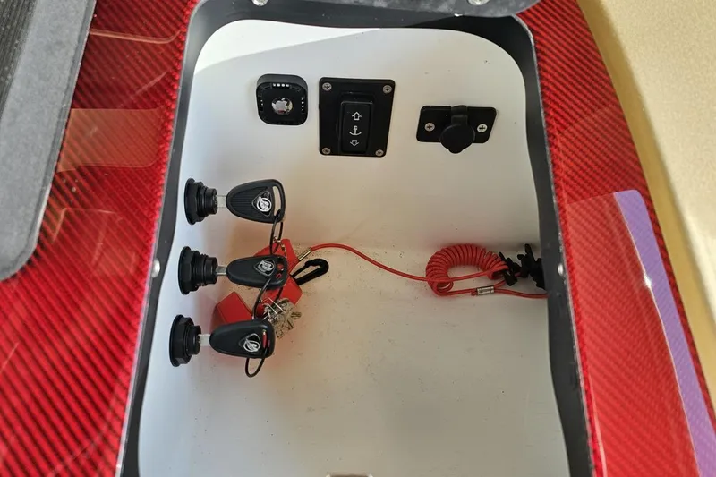 Slide: The Image of Control panel inside a 2017 Statement 380 Open boat, featuring switches and a coiled safety cord. - 40