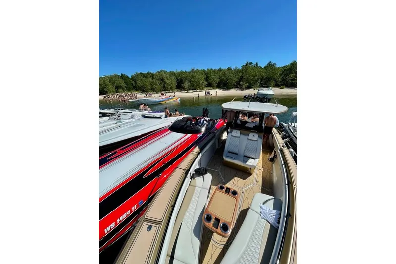 Slide: The Image of 2017 Statement 380 Open boat docked at a sunny beach gathering. - 81