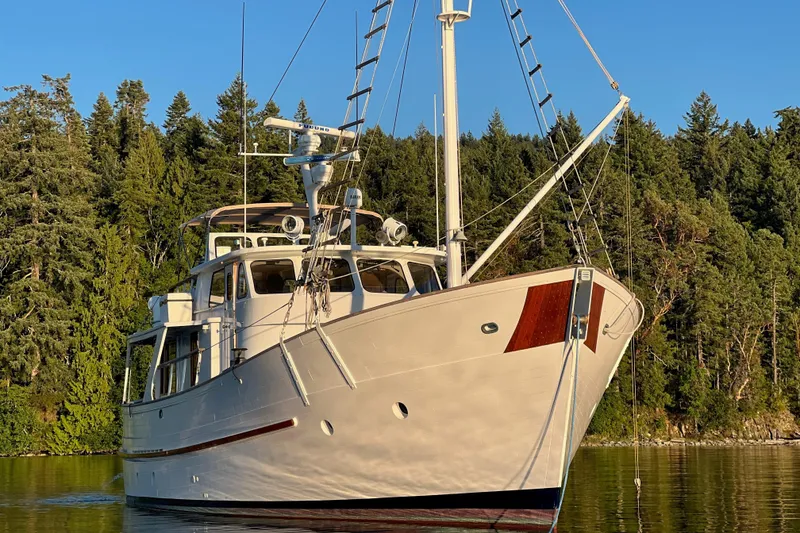 Slide: The Image of Classic 1971 Philbrooks Trawler yacht on serene water with forest backdrop. - 15