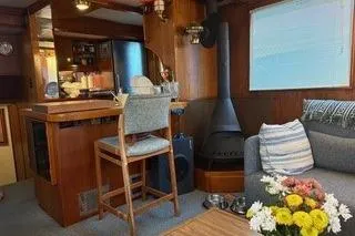 Slide: The Image of 1971 Philbrooks Trawler interior with cozy seating, wood stove, and floral decor. - 3