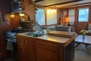 Slide: The Image of 1971 Philbrooks Trawler interior with kitchen, cozy seating, and wooden accents. - 4