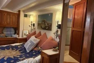 Slide: The Image of Cozy bedroom interior of a 1971 Philbrooks Trawler with nautical decor and wooden furnishings. - 5