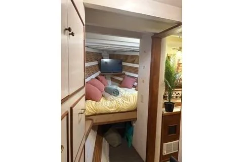 Slide: The Image of Cozy 1971 Philbrooks Trawler cabin with bed, pillows, and TV. - 9