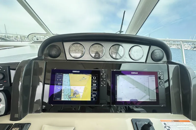 Slide: The Image of Dashboard of a 2006 Sea Ray 48 Sundancer with navigation screens and gauges. - 11
