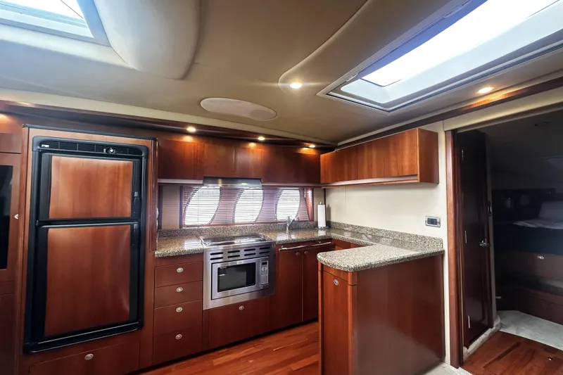 Slide: The Image of Luxurious kitchen interior of 2006 Sea Ray 48 Sundancer yacht with wood cabinetry and modern appliances. - 17
