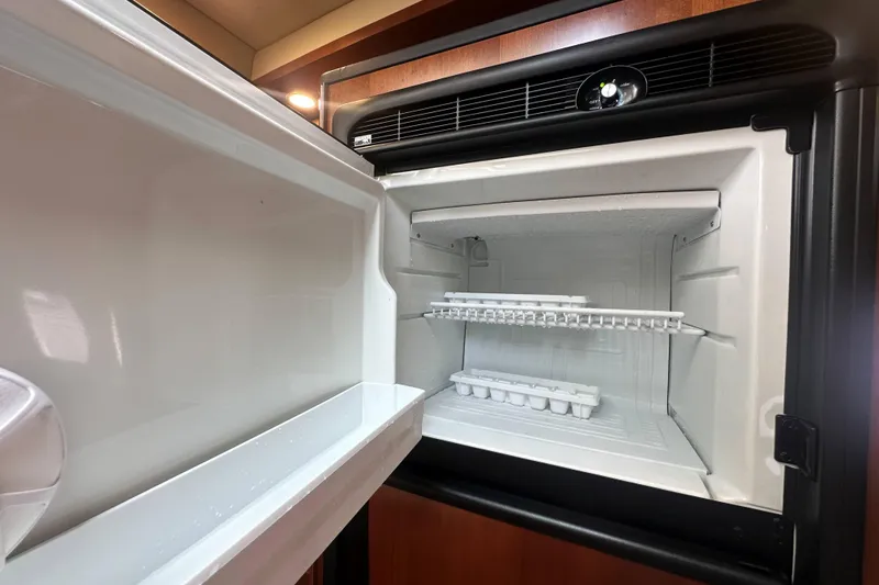 Slide: The Image of Open refrigerator in 2006 Sea Ray 48 Sundancer yacht, featuring ice trays and shelving. - 19