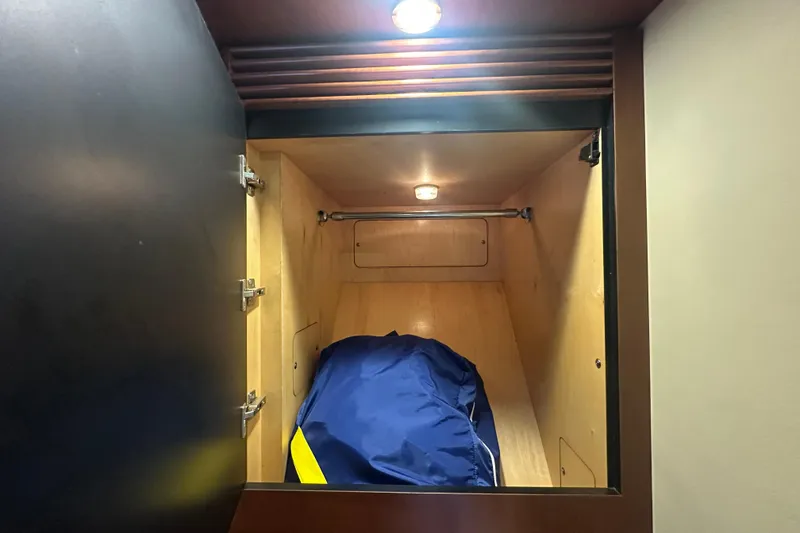 Slide: The Image of Storage compartment inside 2006 Sea Ray 48 Sundancer yacht, featuring wooden interior and overhead light. - 22