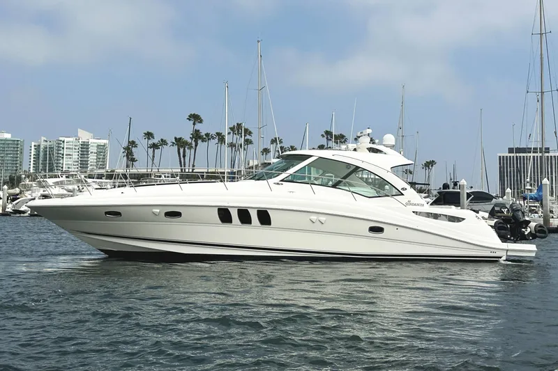 Slide: The Image of 2006 Sea Ray 48 Sundancer yacht docked in marina with cityscape background. - 3