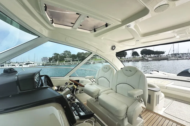 Slide: The Image of Interior view of 2006 Sea Ray 48 Sundancer yacht with luxurious seating and marina backdrop. - 9