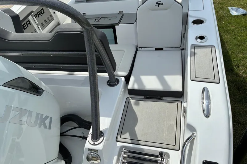 Slide: The Image of 2026 Sea Pro 245FLX Sandbar boat interior with Suzuki engine, featuring seating and storage compartments. - 13