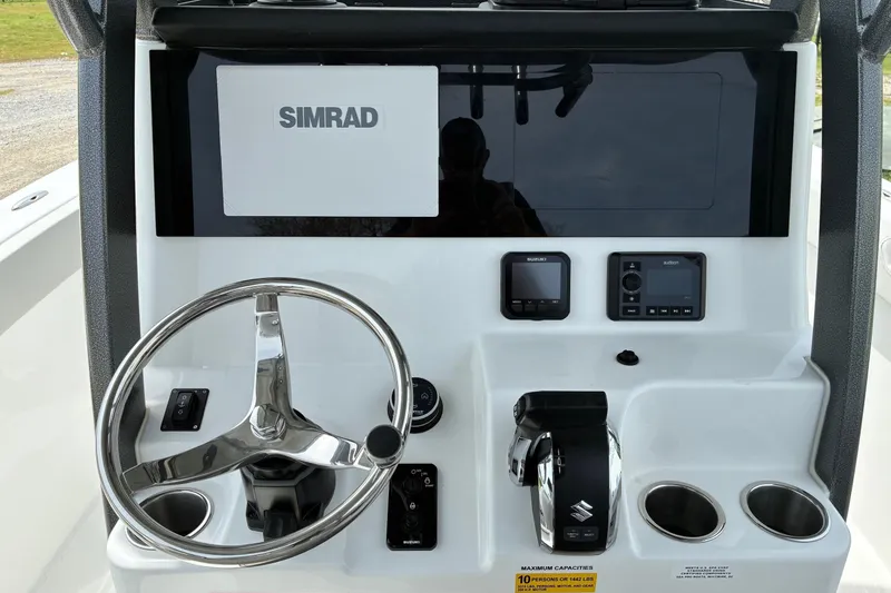 Slide: The Image of 2026 Sea Pro 245FLX Sandbar boat dashboard with Simrad display and Suzuki controls. - 14