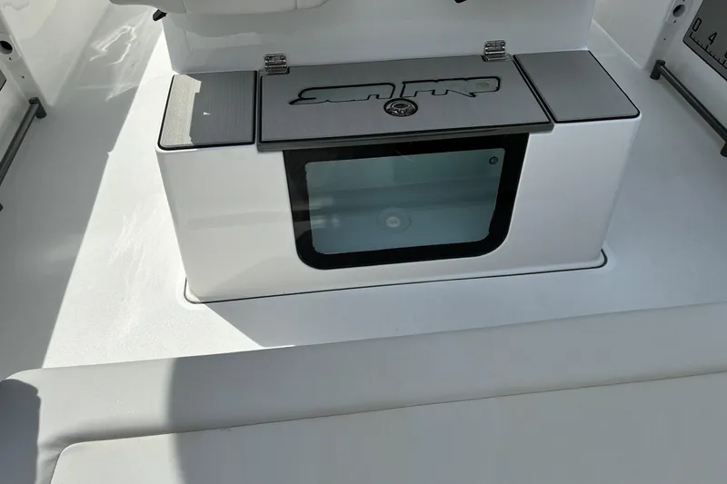 Slide: The Image of 2026 Sea Pro 245FLX Sandbar boat interior with storage compartment and logo. - 21