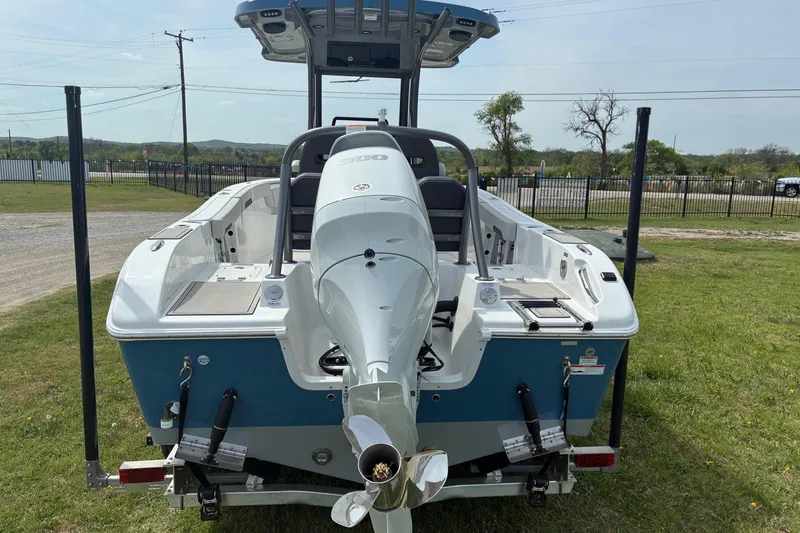 Slide: The Image of 2026 Sea Pro 245FLX Sandbar boat, rear view with outboard motor, parked on grass. - 3