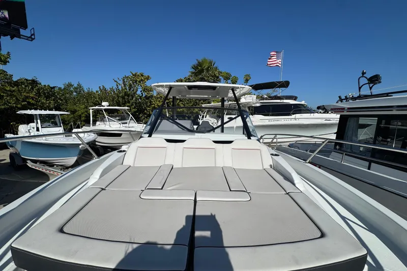 Slide: The Image of 2026 Jeanneau Leader 9.0 WA Series 2 boat with sun deck, docked under clear blue sky. - 19