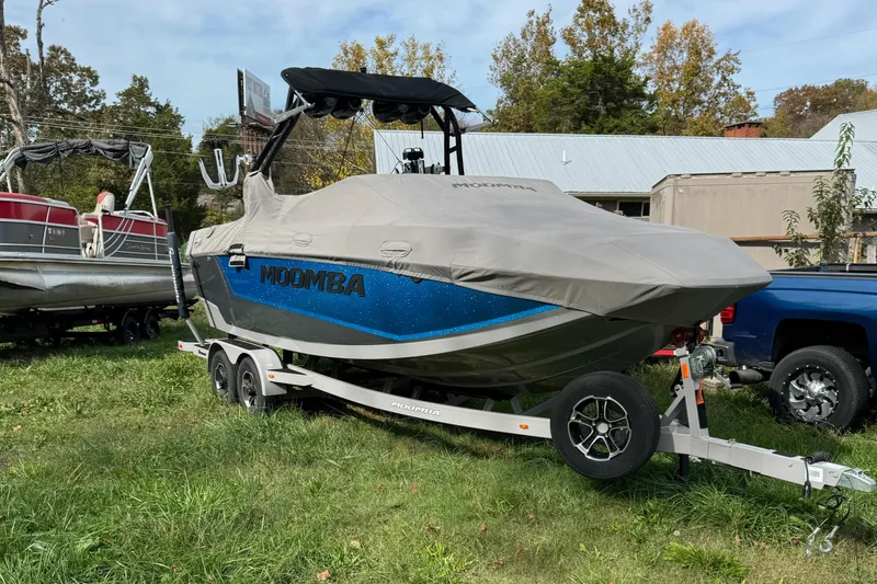 The Image of 2023 Moomba Mojo boat on trailer, covered, parked on grass. - 0