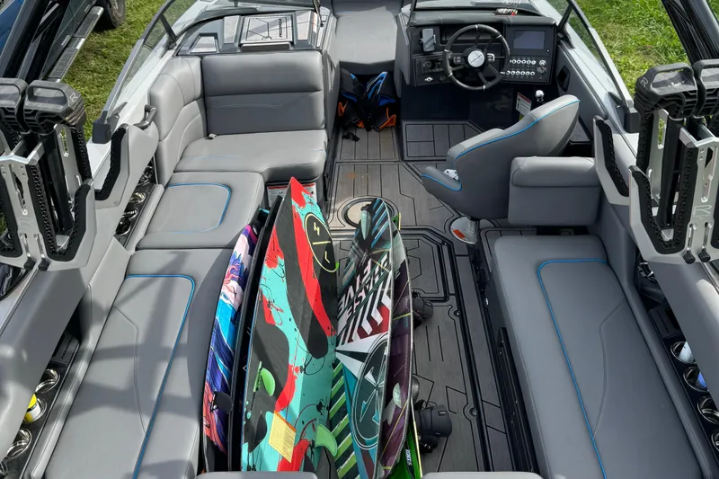 Slide: The Image of 2023 Moomba Mojo boat interior with colorful wakeboards and sleek seating design. - 2