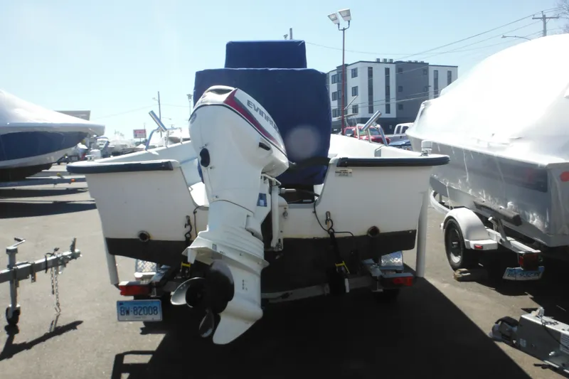 Slide: The Image of 1999 Maritime Skiff 1690 with Evinrude outboard motor on trailer in parking lot. - 13