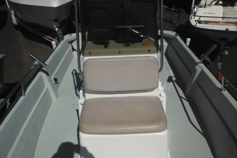 Slide: The Image of 1999 Maritime Skiff 1690 boat interior with cushioned seating and steering console. - 18