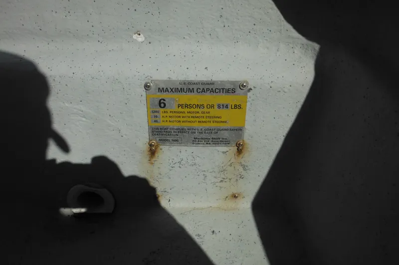 Slide: The Image of 1999 Maritime Skiff 1690 capacity plate showing maximum load and passenger limits. - 21