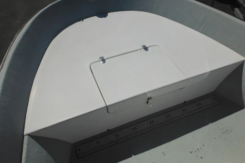 Slide: The Image of 1999 Maritime Skiff 1690 boat interior with storage compartment and measuring ruler. - 26